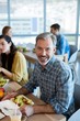 © WavebreakMediaMicro - Smiling man having meal with his colleagues
