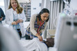 © Cavan Images - Female doctor training coworkers while examining mannequin in hospital