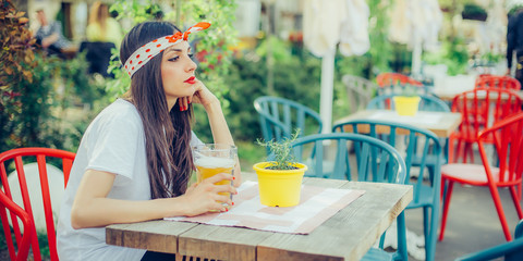 Beautiful young woman drinking beer and enjoying summer day