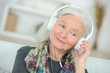 © auremar - senior woman enjoying music in her living room