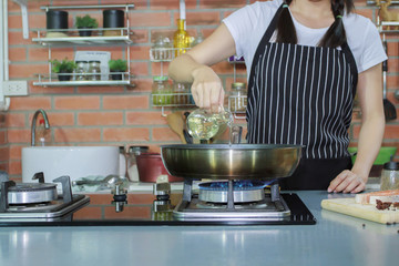 Cropped of hands coocking fish in luxury kitchen