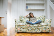 © Emma - Beautiful young woman sitting on colourful sofa