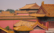 Multiple traditional Chinese yellow tiled rooftops on pink buildings