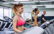 © David Pereiras - Portrait of woman training over a treadmill on fitness center