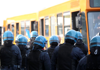 Wall Mural - riot police with protective helmet escort the buses of fans