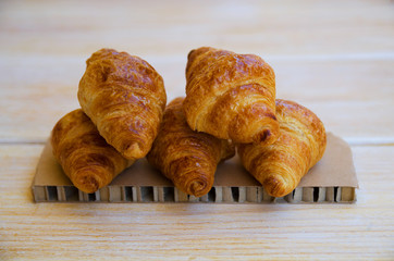 Group of tasty buttery croissants on wooden table. French pastry for breakfast.