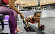© Westend61 - Woman with her trainer working out in gym
