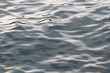 A full frame background of the surface of the deep sea or ocean with gentle, smooth waves ebbing and flowing and shadow and highlight contrasting.