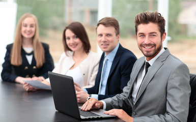  Elegant co-workers looking at camera during meeting in office