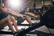 © Flamingo Images - Sportsmen doing exercises with?rowing machine together