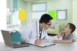 © Creativa Images - Pediatrician checking tongue of a patient in clinic