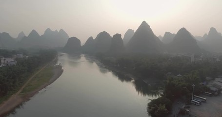 Wall Mural - Aerial shot of passenger boats,rafts in beautiful Li River surrounded by karst mountains at sunset or sunrise in Yangshuo,Guilin,China. Travel, picturesque famous destination and adventure concept.