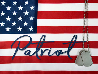 Wall Mural - word patriot and military dog tags on American flag
