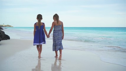 Wall Mural - Little girls walking by the sea on the white beach. Kids on beach vacation in the evening
