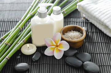 Spa setting with candle , frangipani,towel ,stones ,grove on mat