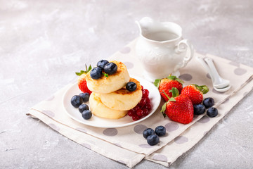 Wall Mural - Cottage cheese pancakes with berries. Selective focus. Russian cheesecakes. Copy space