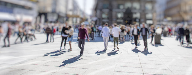 Crowd of anonymous people walking on busy city street