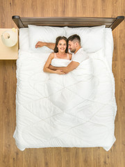 Wall Mural - The happy couple sleeping on the bed. View from above