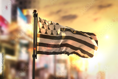 Fototapeta  Brittany Flag Against City Blurred Background At Sunrise Backlight
