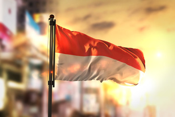 Wall Mural - Indonesia Flag Against City Blurred Background At Sunrise Backlight