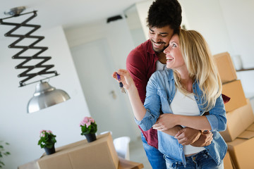 Wall Mural - Young married couple with boxes and holding flat keys