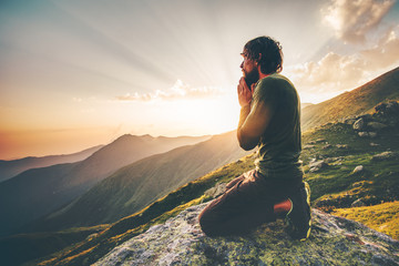 Wall Mural - Man praying at sunset mountains Travel Lifestyle spiritual relaxation emotional concept vacations outdoor harmony with nature landscape
