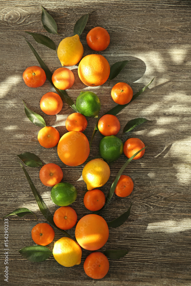 Appetizing fresh citrus fruits on wooden background