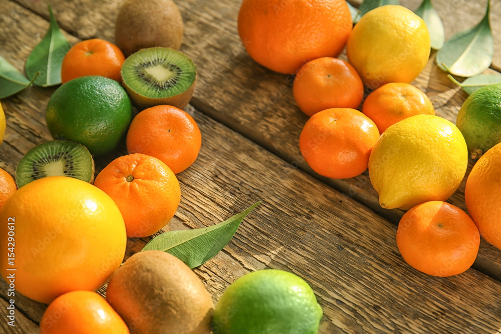 Appetizing fresh citrus fruits with kiwi on wooden background