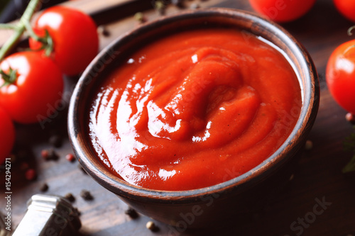 Cuadros en Lienzo Delicious ketchup in bowl with ingredients on tray, closeup