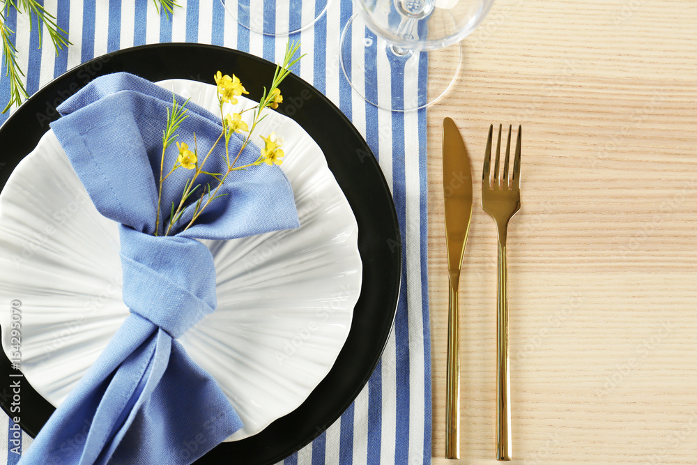 Table setting with lilac color napkin and floral decor on wooden surface