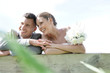 © goodluz - Portrait of bride and groom leaning on fence