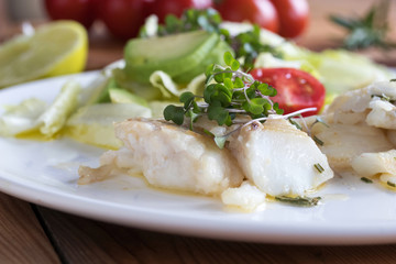 Wall Mural - Baked cod fish with fresh microgreens