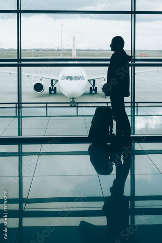 Plakat Człowiek z plecakiem podróży czeka na wejście na pokład samolotu