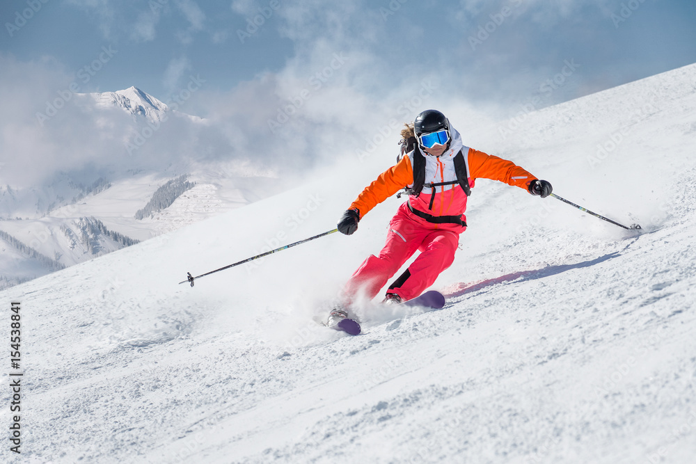 Female skier on a slope in the mountains - obrazy, fototapety, plakaty 