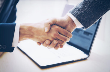 Close up view of business partnership handshake concept.Photo two businessman handshaking process.Successful deal after great meeting.Horizontal, blurred background.