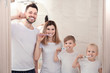 © Africa Studio - Young couple and their children brushing teeth in bathroom