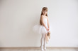 © Africa Studio - Beautiful little ballerina holding ballet shoes in light dance studio