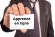 © Richard Villalon - Homme tenant une carte avec apprenez en ligne écrit dessus
