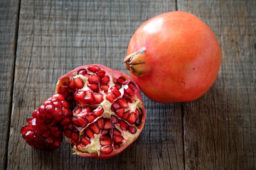 Wall Mural - Ripe pomegranate fruit on wooden vintage background.