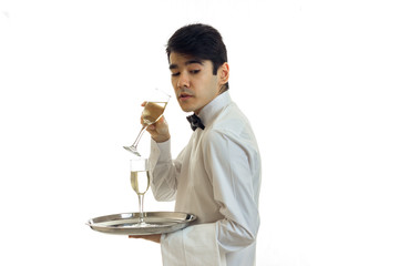 Wall Mural - charming young waiter's shirt stands sideways quite imperceptibly forward and holds in his hand a glass of wine