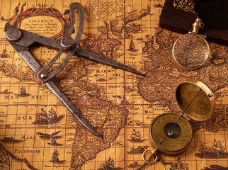 Old vintage retro compass on ancient world map. Vintage still life. Travel geography navigation concept background.