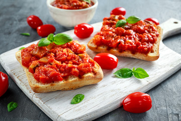 Wall Mural - Fresh homemade crispy Italian appetizer Bruschetta topped with tomato, eggplant, Zucchini, Yellow pepper, garlic and basil on white wooden board. healthy food