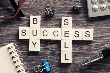 Buy sell success concepts collected in crossword on wooden table