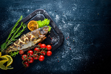 Wall Mural - Trout fish baked with aromatic herbs and spices. On Wooden background.