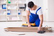 © Elnur - Young worker working on floor laminate tiles