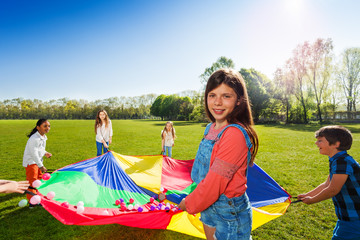 Wall Mural - girl holding rainbow parachute with colorful balls