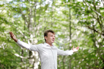 Wall Mural - Young man with open wide arms celebrating success