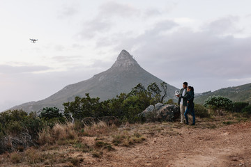 Young couple guiding a drone through a remote control