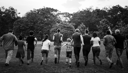 Wall Mural - Group of people walking and running playful in the park