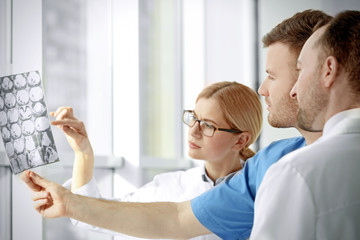 Wall Mural - Group of doctors looking at roentgenogram in clinic